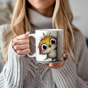 May include: White ceramic mug featuring a whimsical illustration of a cartoon owl with large, expressive eyes. The owl is depicted in shades of yellow, orange, and brown, peeking from behind a wooden post. The mug has a white handle.