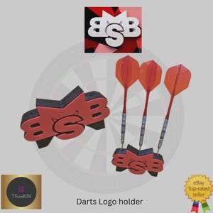 May include: A red and black darts logo holder with three orange darts. The holder features the letters "BSB" in a stylized font. The image also includes a dartboard in the background and the text "Darts Logo holder".
