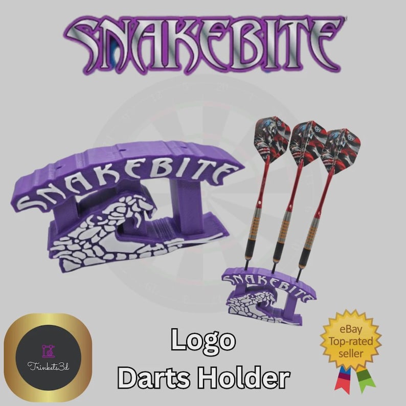 May include: Purple "Snakebite" logo darts holder with three darts. The holder has a snake design and the text "Snakebite". The darts have red shafts and patterned flights. The image also includes the text "Logo Darts Holder".