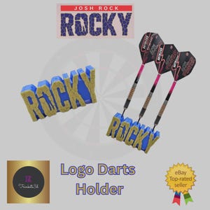 May include: A blue and gold "ROCKY" logo darts holder with three darts. The darts have pink and black flights. The image also includes a "JOSH ROCK" logo and the text "Logo Darts Holder".