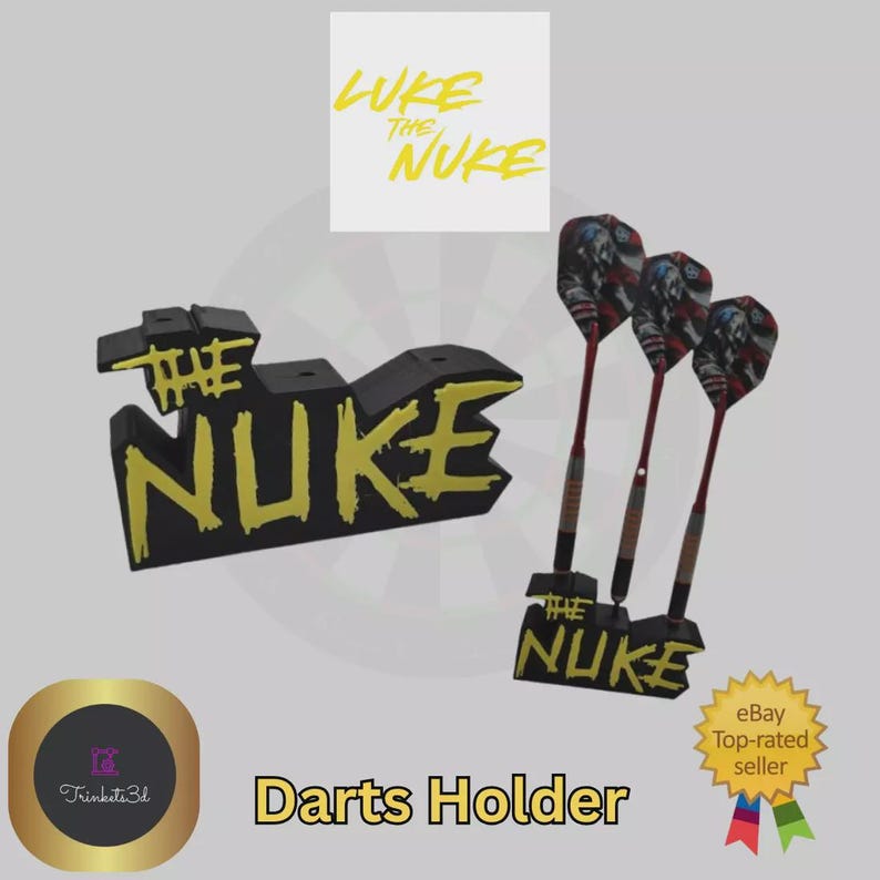 May include: Black and yellow "The Nuke" darts holder with three darts. The darts have red shafts and American flag-themed flights. The text "Luke the Nuke" is above the holder. The words "Darts Holder" are at the bottom.