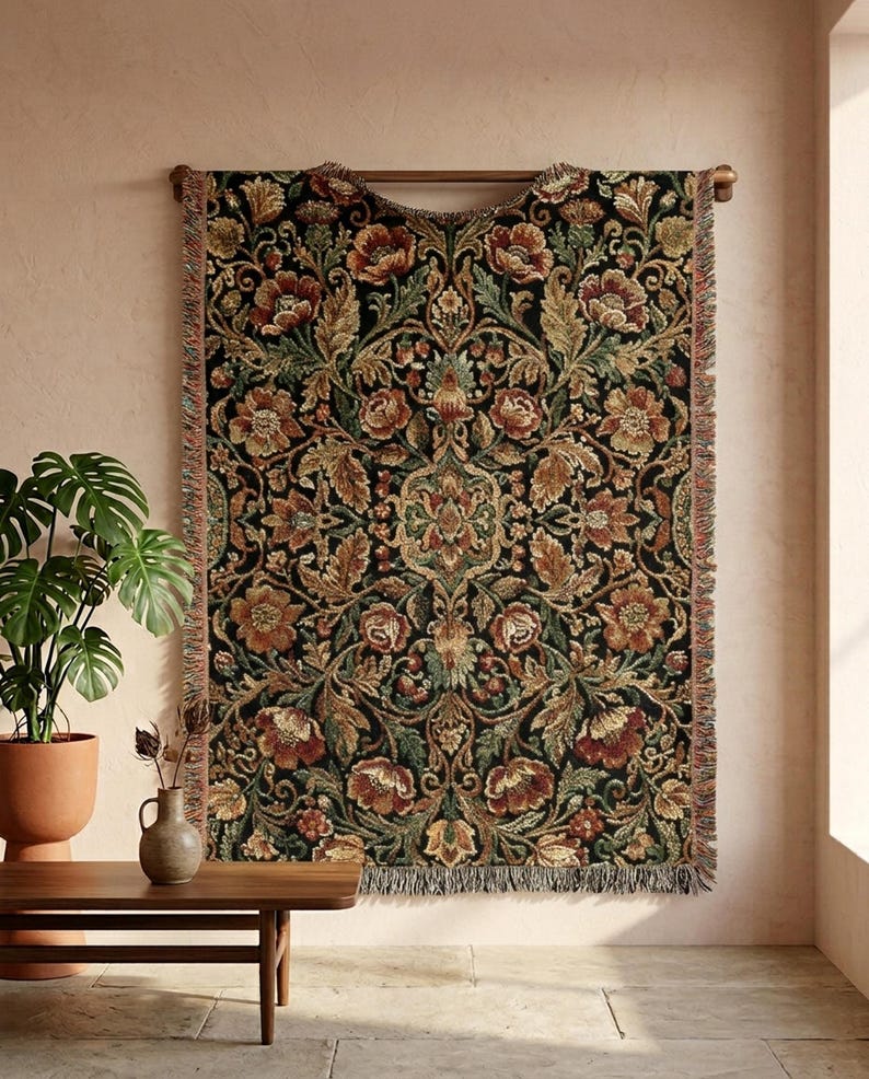May include: A tapestry with a floral pattern in shades of brown, red, and green against a black background. The tapestry is rectangular with a fringed edge and is mounted on a wooden rod. The design features stylized flowers and leaves.