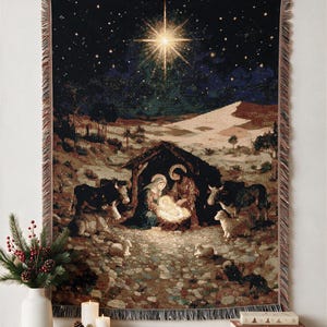 May include: A woven wall tapestry featuring a nativity scene with a central glowing manger, figures of Mary and Joseph, and surrounding livestock under a dark night sky with a prominent bright star, finished with a decorative fringed edge.