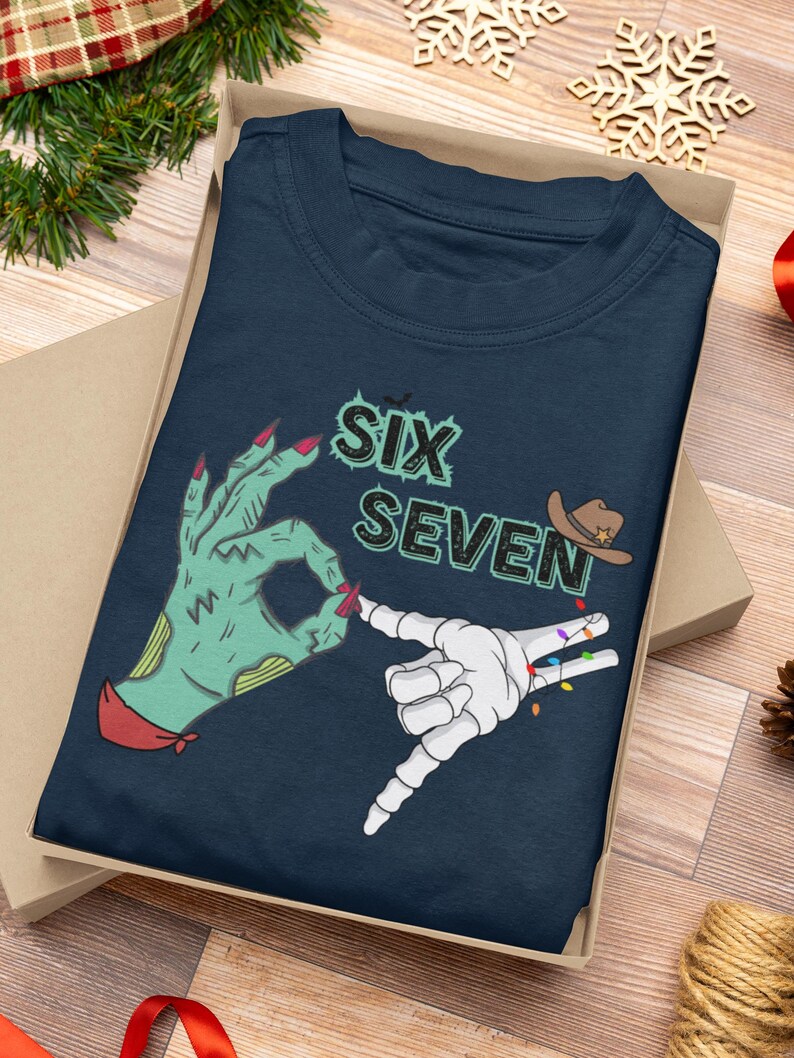 May include: Navy blue t-shirt with the text "SIX SEVEN" and graphic hands. One hand is green with red nails, the other is a white skeleton hand with colorful lights. A cowboy hat graphic is also included.