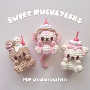 May include: Three crocheted animal figures in shades of brown, pink, and white, each topped with a whipped cream and cherry design. The text "SWEET MUSKETEERS" and "PDF crochet pattern" are displayed above and below the figures.