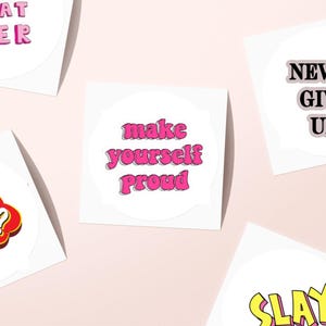 May include: A collection of white stickers with motivational phrases in various fonts and colors. Phrases include "Whatever," "Make Yourself Proud," "Never Give Up," "Huh!?" and "Slay."