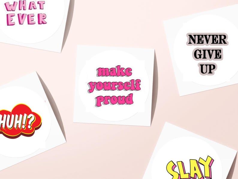 May include: A collection of white stickers with motivational phrases in various fonts and colors. Phrases include "Whatever," "Make Yourself Proud," "Never Give Up," "Huh!?" and "Slay."
