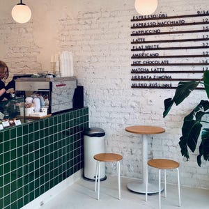 Barbershop interior featuring a wooden menu board with services listed.