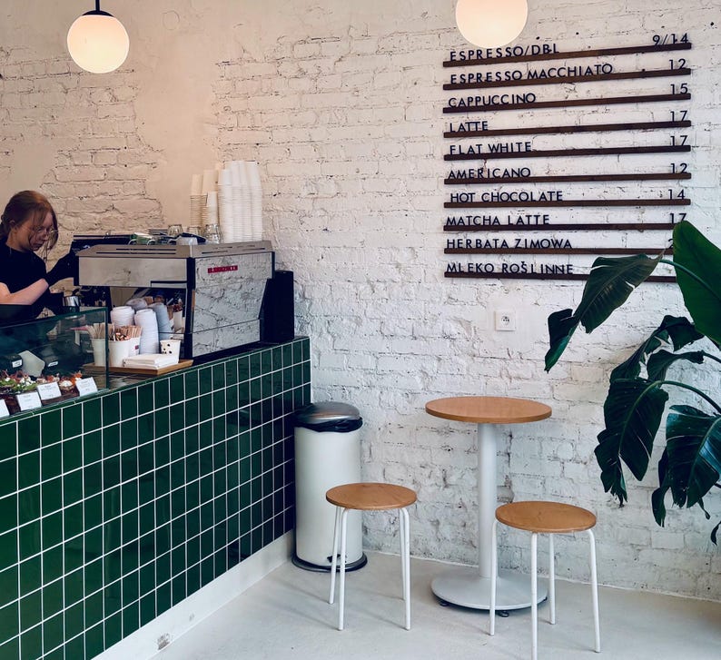 Barbershop interior featuring a wooden menu board with services listed.
