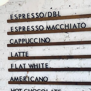 Side view of wall-mounted wooden menu rails with customizable letters.