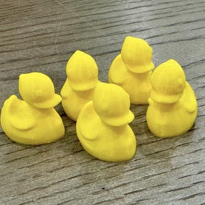 May include: Five yellow rubber duck toys. The ducks are all different sizes and shapes, but they all have the same bright yellow color.