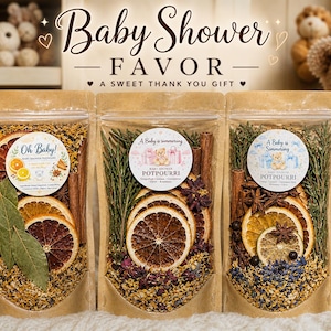 May include: Three clear pouches filled with potpourri, featuring dried orange slices, cinnamon sticks, and herbs. Each pouch has a circular label with text that reads "Baby Shower Favor" and "A Sweet Thank You Gift". The background includes teddy bears.