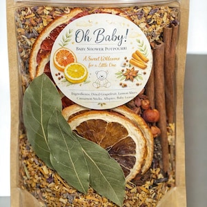 May include: A clear, resealable bag filled with potpourri for a baby shower. The bag contains dried grapefruit and lemon slices, cinnamon sticks, and other spices. A circular label reads "Oh Baby! Baby Shower Potpourri, A Sweet Welcome for a Little One."