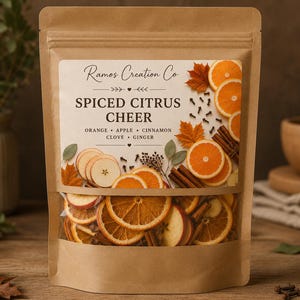May include: A brown kraft paper pouch containing dried fruit and spices, labeled Ramos Creation Co Spiced Citrus Cheer. The label features illustrations of orange slices, apple slices, cinnamon sticks, cloves, and autumn leaves.