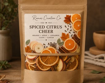 May include: A brown kraft paper pouch containing dried fruit and spices, labeled Ramos Creation Co Spiced Citrus Cheer. The label features illustrations of orange slices, apple slices, cinnamon sticks, cloves, and autumn leaves.