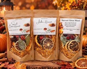 May include: Three brown kraft paper pouches containing natural simmer pot ingredients. Labels read Spiced Citrus Harvest, Amber Harvest, and Harvest Citrus Blend, featuring dried orange slices, cinnamon sticks, star anise, and various dried botanicals.