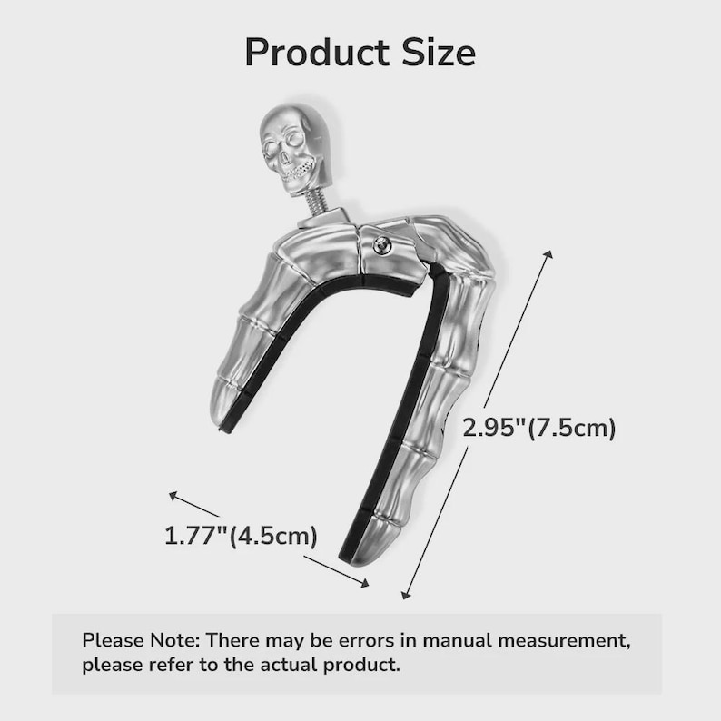 Op de afbeelding: Zilverkleurige gitaarcapo met een schedelkop en een skelet hand ontwerp. De capo is 7,5 cm lang en 4,5 cm breed. De tekst "Product Size" staat bovenaan.
