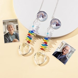 May include: Two memorial suncatchers with heart-shaped crystal pendants and rainbow-colored beads. Each suncatcher has a circular charm with a photo and the phrases "I'm Always With You" and "Forever In Our Hearts".