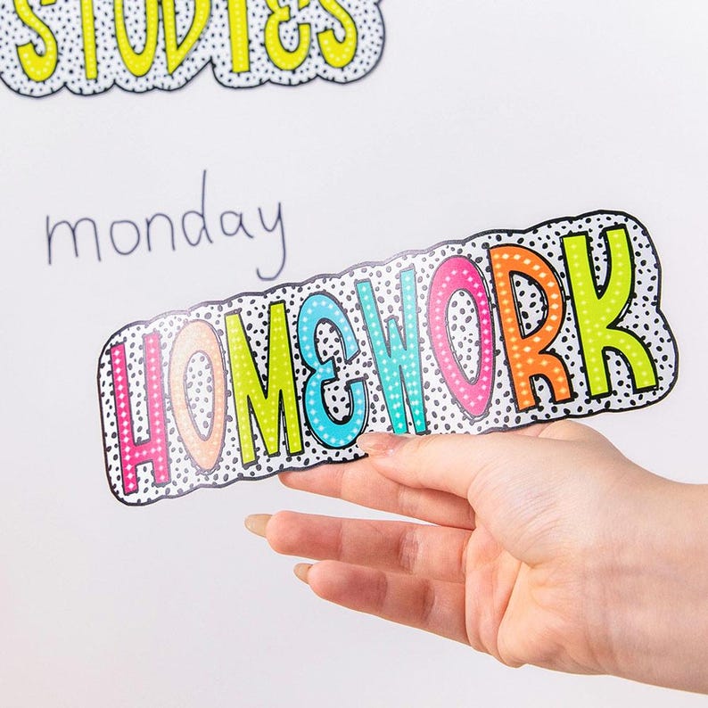 Puede incluir: Un letrero colorido de "HOMEWORK" con un borde punteado negro, sobre un fondo blanco. Las letras son de varios colores, incluyendo naranja, rosa, verde y azul, con lunares blancos. La palabra "STUDIES" es visible arriba.