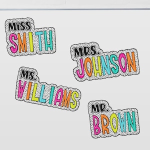 Puede incluir: Cuatro etiquetas de nombre coloridas con los t&iacute;tulos "Miss", "Mrs.", "Ms." y "Mr." seguidos de los nombres "Smith", "Johnson", "Williams" y "Brown". Cada etiqueta tiene un borde punteado negro y una combinaci&oacute;n de colores &uacute;nica, incluyendo rosa, naranja, amarillo y turquesa.