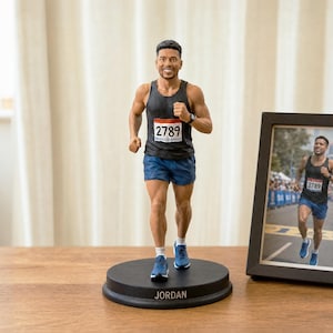 Puede incluir: Una figura personalizada de un corredor con camiseta negra sin mangas con el número 2789, pantalones cortos azules y zapatillas de correr azules. La figura se apoya en una base redonda negra con el nombre JORDAN en blanco, junto a una foto.