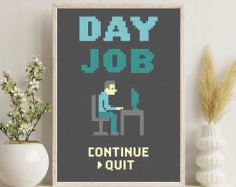 May include: Framed art print with a pixelated design. The artwork features the words "DAY JOB" in teal and a pixelated person at a computer. Below the person, the text reads "CONTINUE > QUIT" in a retro video game style.