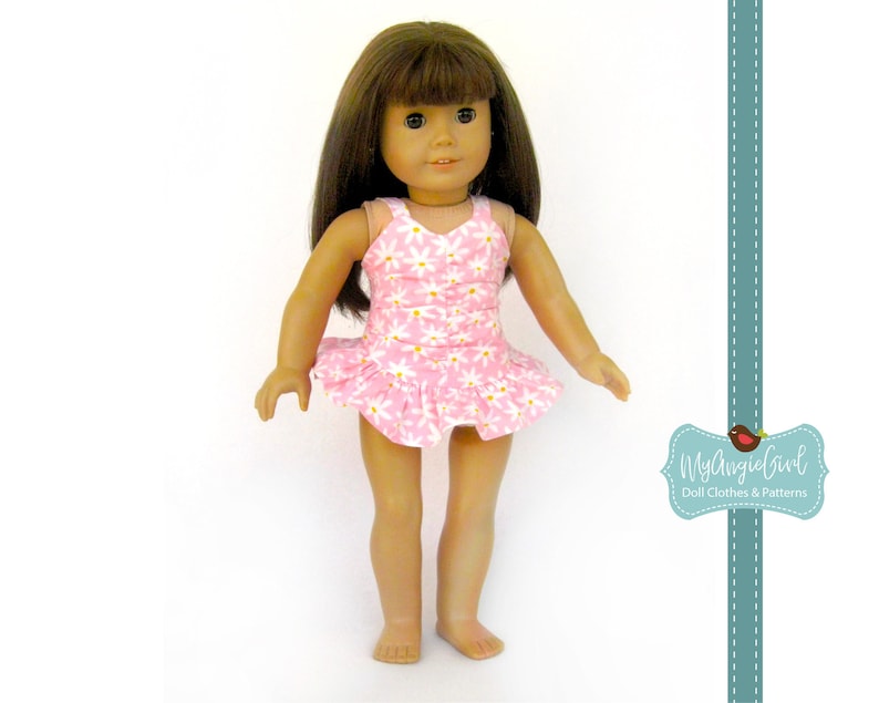 May include: A doll wearing a pink swimsuit with a white daisy pattern. The swimsuit has a ruffled skirt. The doll has brown hair and is standing against a white background. The image includes the text "MyAngieGirl Doll Clothes & Patterns".
