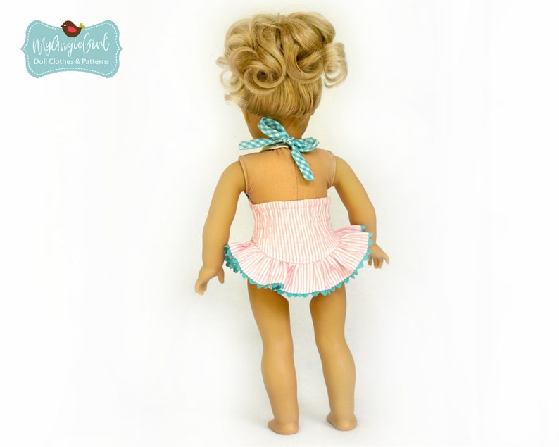 Puede incluir: Una mu&ntilde;eca con un traje de ba&ntilde;o a rayas rosas y blancas con una falda con volantes y ribete turquesa. El traje de ba&ntilde;o tiene un cuello halter con un lazo de cuadros. La mu&ntilde;eca tiene el pelo rubio peinado en dos mo&ntilde;os. Incluye el texto "MyAngieGirl Doll Clothes & Patterns".