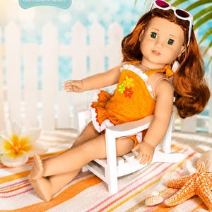 Puede incluir: Una mu&ntilde;eca con cabello rojo que lleva un traje de ba&ntilde;o naranja y gafas de sol, sentada en una silla blanca sobre una toalla de playa a rayas. La mu&ntilde;eca est&aacute; en una escena de playa con una valla blanca y hojas de palmera. La mu&ntilde;eca lleva un traje de ba&ntilde;o con flores.