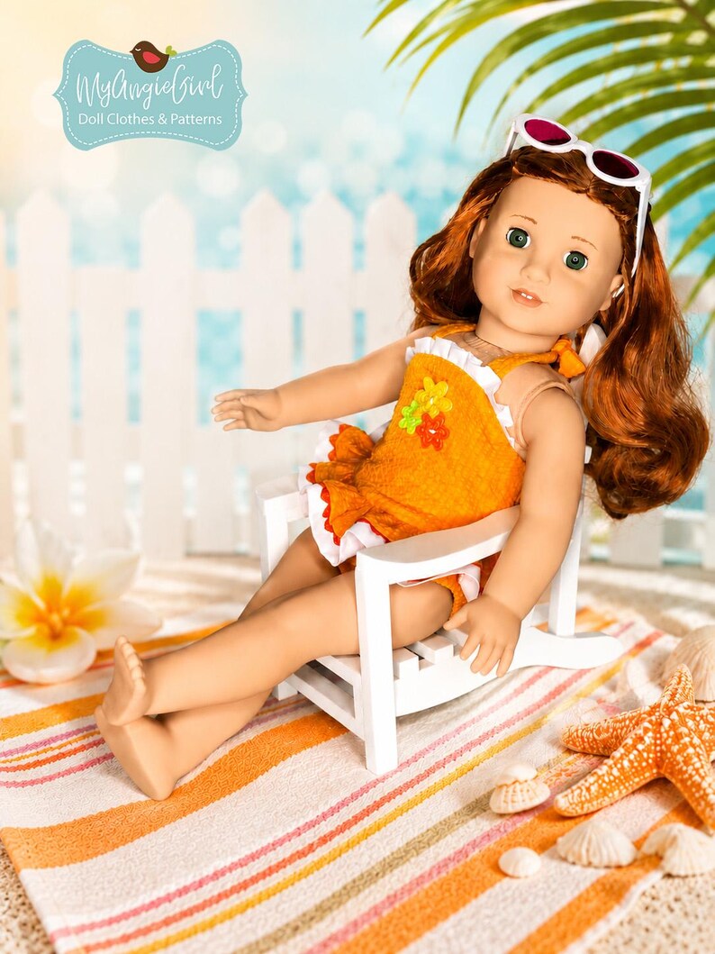 Puede incluir: Una mu&ntilde;eca con cabello rojo que lleva un traje de ba&ntilde;o naranja y gafas de sol, sentada en una silla blanca sobre una toalla de playa a rayas. La mu&ntilde;eca est&aacute; en una escena de playa con una valla blanca y hojas de palmera. La mu&ntilde;eca lleva un traje de ba&ntilde;o con flores.