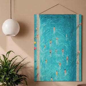 Könnte beinhalten: Ein rechteckiger Wandkunstdruck, der ein Schwimmbad aus der Vogelperspektive zeigt. Das türkisfarbene Wasser ist mit Schwimmern in bunten Badeanzügen gefüllt. Das Kunstwerk hängt an einer beigefarbenen Wand, mit einer weißen Kugelleuchte und einer grünen Pflanze im Vordergrund.