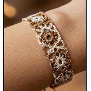 Puede incluir: Primer plano de una pulsera de ganchillo hecha a mano en tonos marrón y crema. El diseño calado presenta motivos florales y una textura delicada y de encaje. Este accesorio de estilo bohemio es perfecto para añadir un toque artesanal.