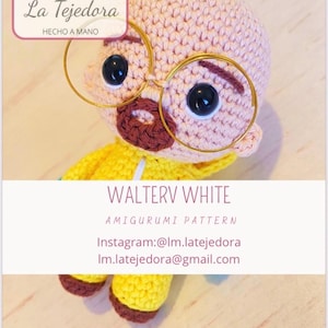Puede incluir: Muñeco amigurumi hecho a mano de Walter White, con cabeza rosa claro, ojos negros y bigote marrón. El muñeco lleva gafas con montura dorada y una chaqueta amarilla. El texto "WALTERV WHITE" se muestra debajo.