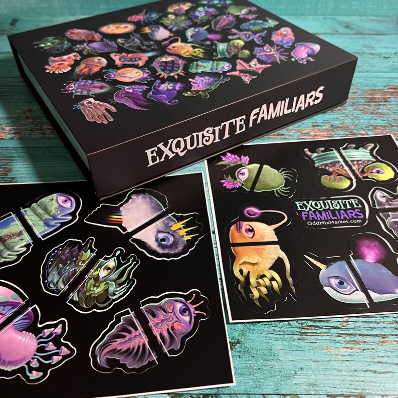 Puede incluir: Una caja negra con el texto "EXQUISITE FAMILIARS" en la parte delantera. La caja contiene un conjunto de pegatinas con criaturas coloridas y caprichosas. Las pegatinas est&aacute;n en cartulina negra y est&aacute;n divididas en dos conjuntos.