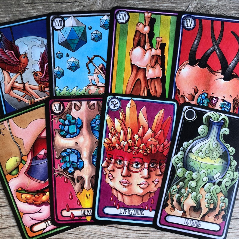 May include: A set of ten tarot cards with colorful illustrations. The cards feature a variety of imagery, including skulls, crystals, and a person with multiple faces. The cards are numbered from XII to XV. The text on the cards includes "Death", "Everything", and "Nothing".