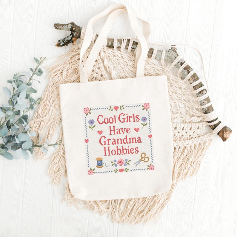 Looking for a funny cross stitch pattern for a craft lover? This Cool Girls Have Grandma Hobbies PDF pattern is a charming choice for stitchers, makers, and creative friends. The design features a readable quote in classic cross stitch lettering, surrounded by traditional flowers, hearts, craft tools, and a simple border. It has a cozy vintage feel that makes it perfect for framed wall art, handmade decor, or a unique gift for someone who loves grandma hobbies.