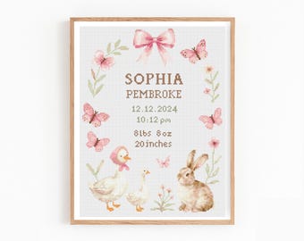 May include: A framed cross-stitch birth announcement featuring the name SOPHIA PEMBROKE, the date 12.12.2024, time 10:12 pm, weight 8lbs 8oz, and length 20 inches. The design includes a pink bow, butterflies, flowers, two geese, and a rabbit.