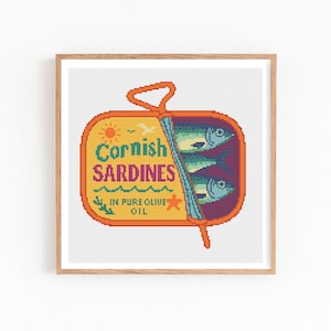 May include: A framed cross-stitch depicting a tin of Cornish sardines. The orange tin features the text "Cornish Sardines" in teal, pink, and yellow. Inside are three fish, with the text "In Pure Olive Oil".
