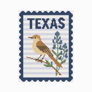 May include: Cross-stitch design of a postage stamp featuring the word "TEXAS" in navy blue block letters. A brown bird perches on a branch next to bluebonnet flowers. The stamp has a navy blue border with a perforated edge.