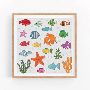 以下が含まれることがあります： 様々な魚、ヒトデ、海藻、サンゴを特徴とするカラフルなクロスステッチパターン。魚は赤、オレンジ、黄色、緑、青、紫の色合いです。背景は薄い青色です。