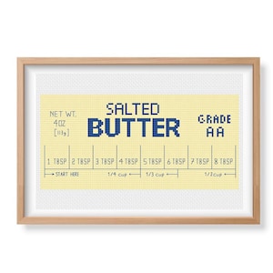 May include: A yellow and white cross-stitch pattern for a salted butter stick. The pattern includes the text "SALTED BUTTER" and "GRADE AA". The pattern also includes measurements for tablespoons and cups.