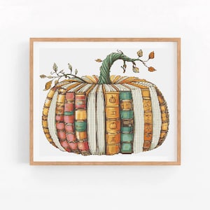 Könnte beinhalten: Ein gerahmtes Kreuzstich-Kunstwerk zeigt einen Kürbis aus Büchern. Der Kürbiskörper besteht aus farbenfrohen Buchrücken, mit einem grünen Stiel und Blattranken. Das Kunstwerk ist vor einem weißen Hintergrund angeordnet.