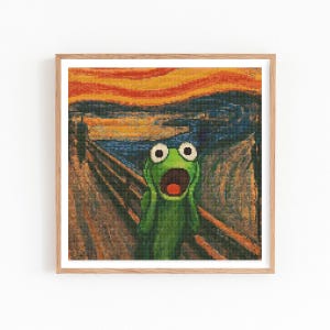 May include: Framed artwork featuring a pixelated image of Kermit the Frog in a parody of Edvard Munch's "The Scream." The frog's green face is contorted in a scream, with large white eyes and a red open mouth. The background depicts a sunset over a bridge.