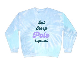 以下が含まれることがあります： 黒と紫の文字で「Eat Sleep Pole Repeat」と書かれた、薄い青色のタイダイ染めのスウェットシャツです。
