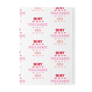 May include: White wrapping paper with a repeating pattern of pink and red hearts and the text "In My Pole Dance Era".