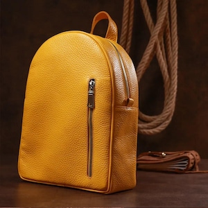 Ein Damenlederrucksack in 3 Farben - Gelb, Schwarz und Braun - verleiht Ihrem Bild Glanz und Frühlingsstimmung. Gutes Geschenk für ein Mädchen
