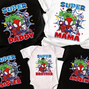 May include: A collection of superhero-themed t-shirts and a onesie. The shirts are black and white, featuring the words "SUPER" and "DADDY", "MAMA", "SISTER", "BROTHER", and "ANDREW". Each shirt has a graphic of Spider-Man, Hulk, and other characters.