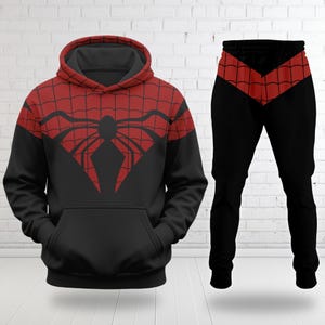 May include: A black and red hooded sweatshirt and matching sweatpants set. The hoodie features a red upper section with a black spider web pattern and a large black spider emblem on the chest. The pants have a red webbed waistband.