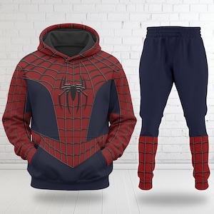 May include: A two-piece Spider-Man costume set. The hooded sweatshirt is red with a black spiderweb design and a navy blue centre. The matching trousers are navy blue with red cuffs. The Spider-Man logo is on the chest.