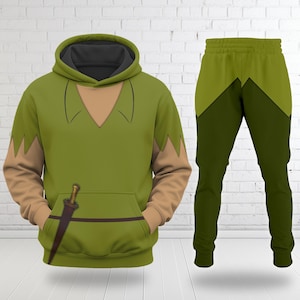 May include: Green hooded sweatshirt and matching trousers set. The sweatshirt has a tan neckline and sleeves, with a brown sword graphic. The trousers are a darker green with a lighter green accent.